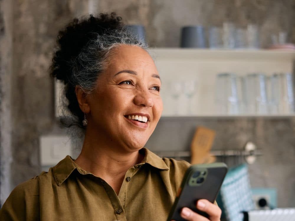 mature age woman and adult son look at tablet screen